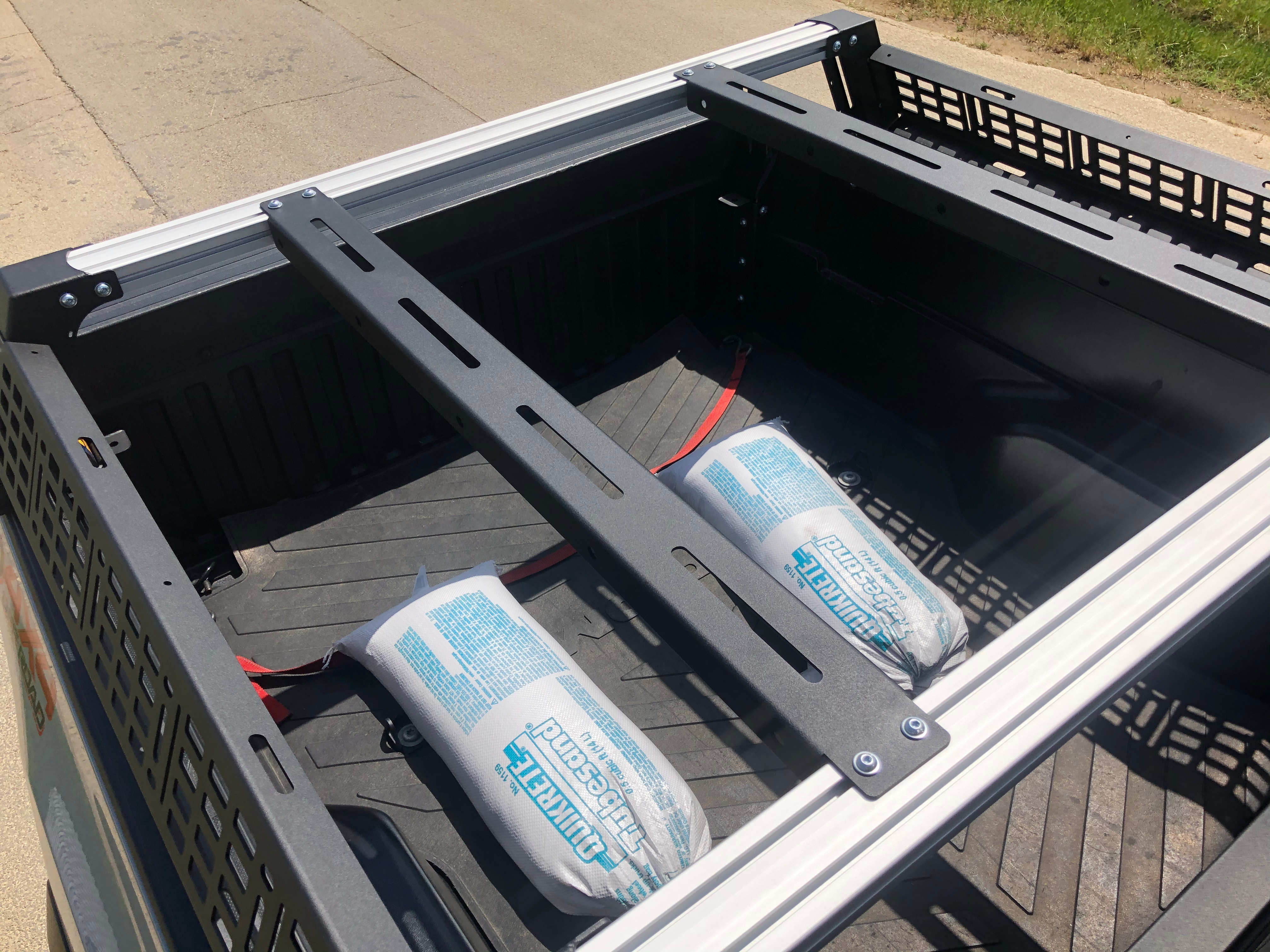 Overland truck bed rack system with cargo bars and loaded gear bags