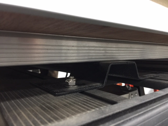 Close-up of overland roof rack mounting bracket with bolt on vehicle, adventure gear accessory