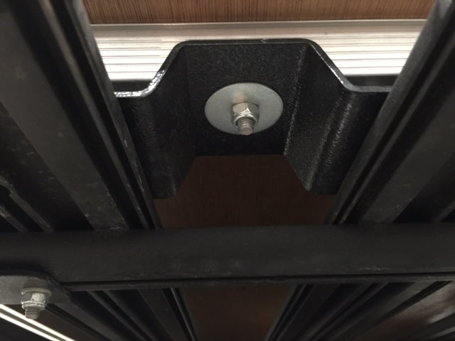 Close-up of metal roof rack mounting bracket with bolt, for overlanding vehicle accessories