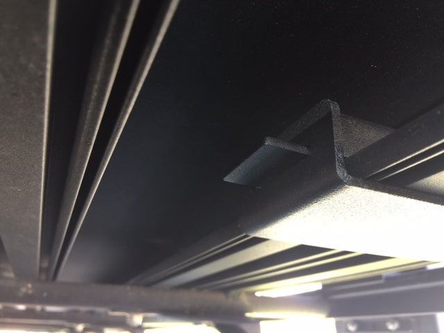 Close-up of a black metal roof rack mounting bracket for overlanding vehicle accessories