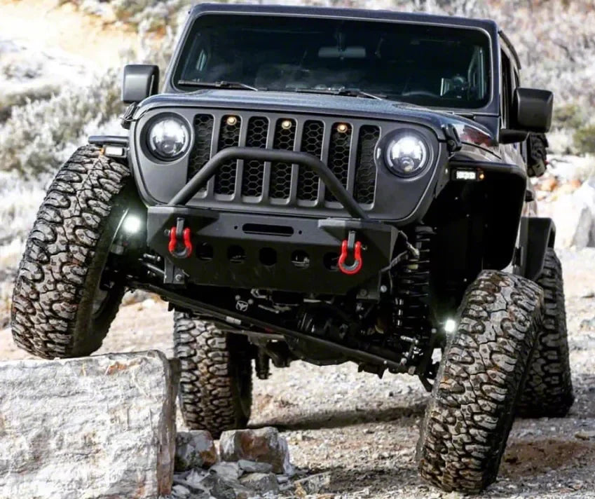 Jeep Wrangler outfitted for off-road overlanding flexing on rocky terrain