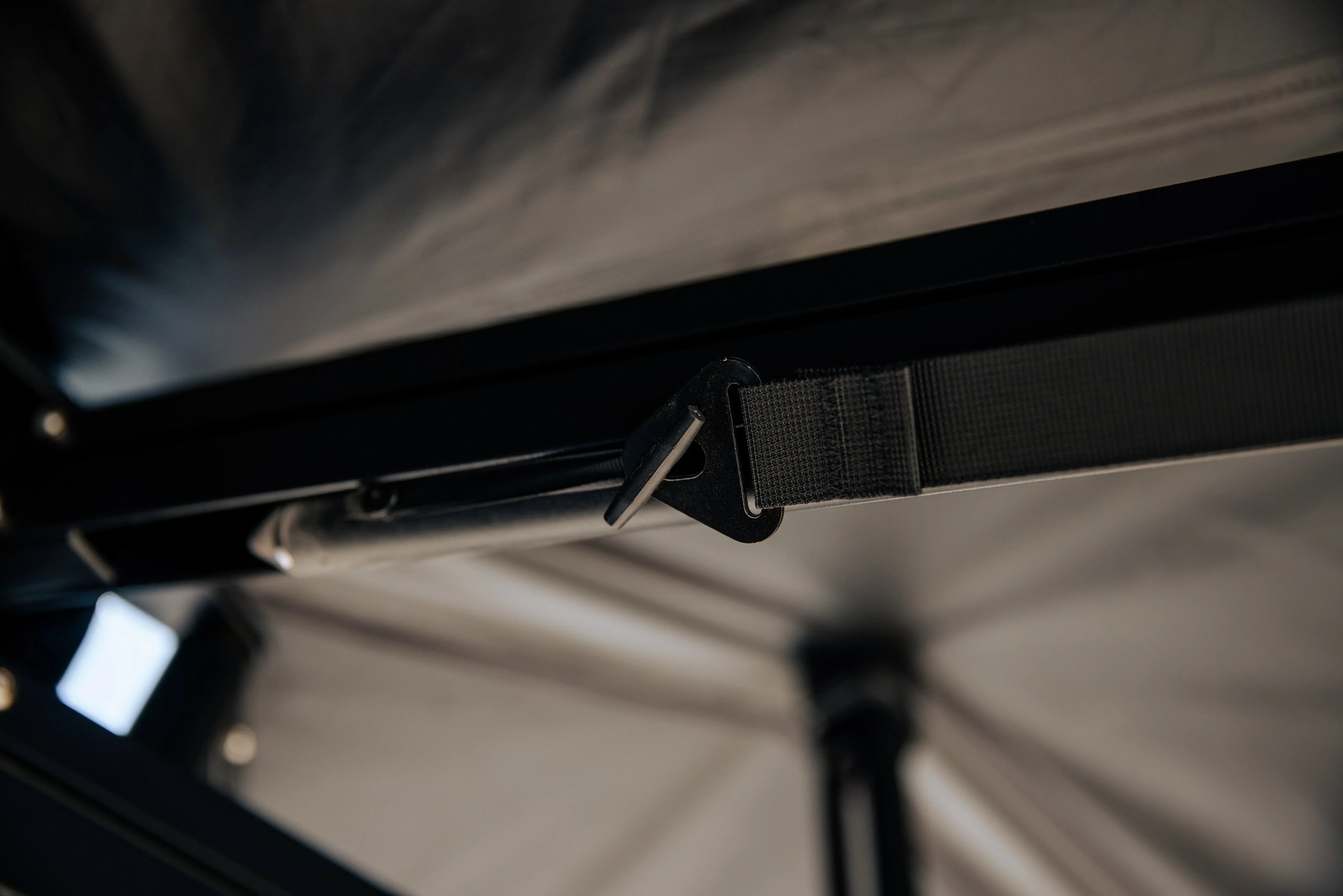Close-up of metal frame and strap attachment on overland rooftop tent interior