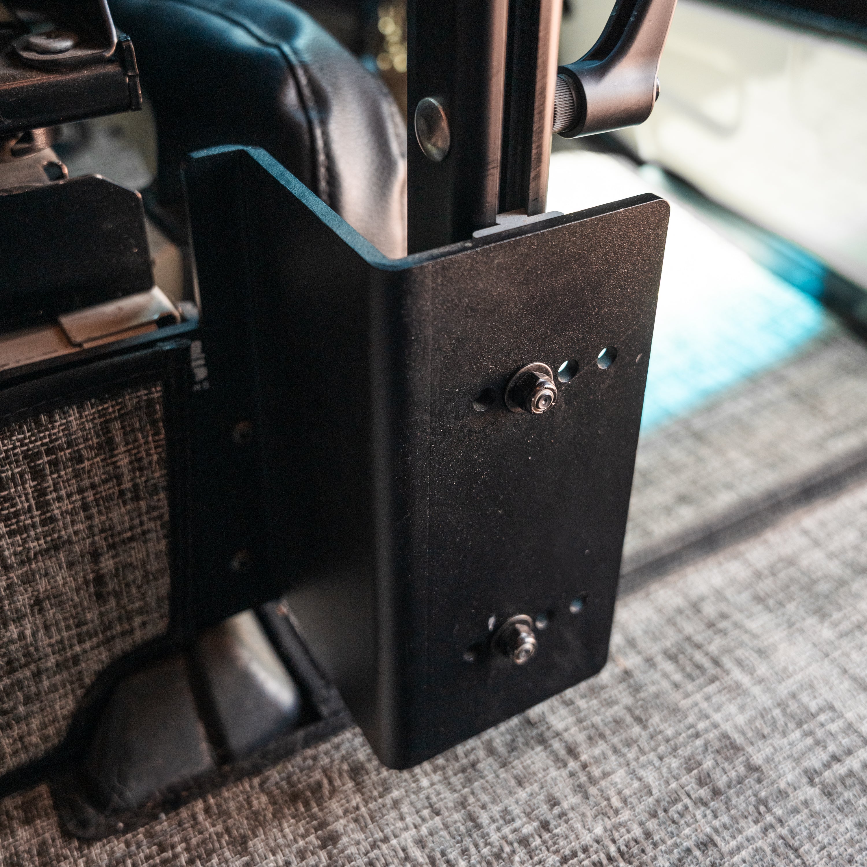 Close-up of a black metal accessory mounting bracket installed in a vehicle interior