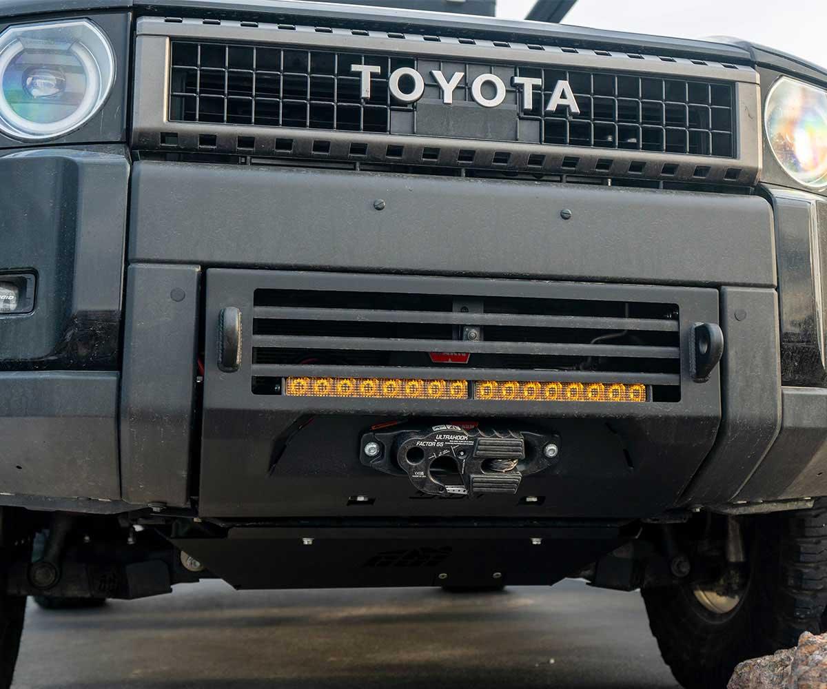 Toyota off-road bumper with integrated winch and LED light bar on rugged vehicle