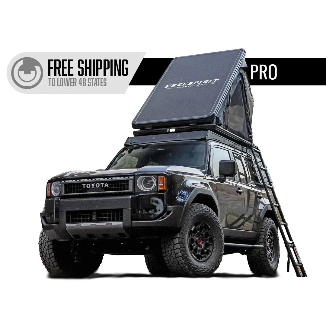 Toyota Land Cruiser with rooftop tent, ladder, and off-road camping gear
