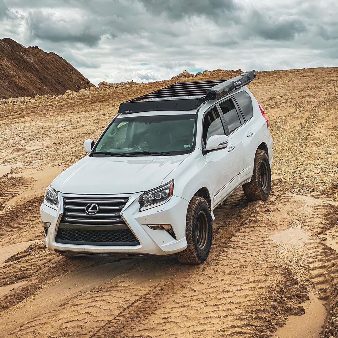 White Lexus GX460 with Prinsu roof rack off-road on a sandy trail under cloudy sky