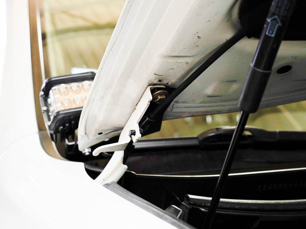 Close-up of hood ditch bracket mount with auxiliary LED light installed on vehicle