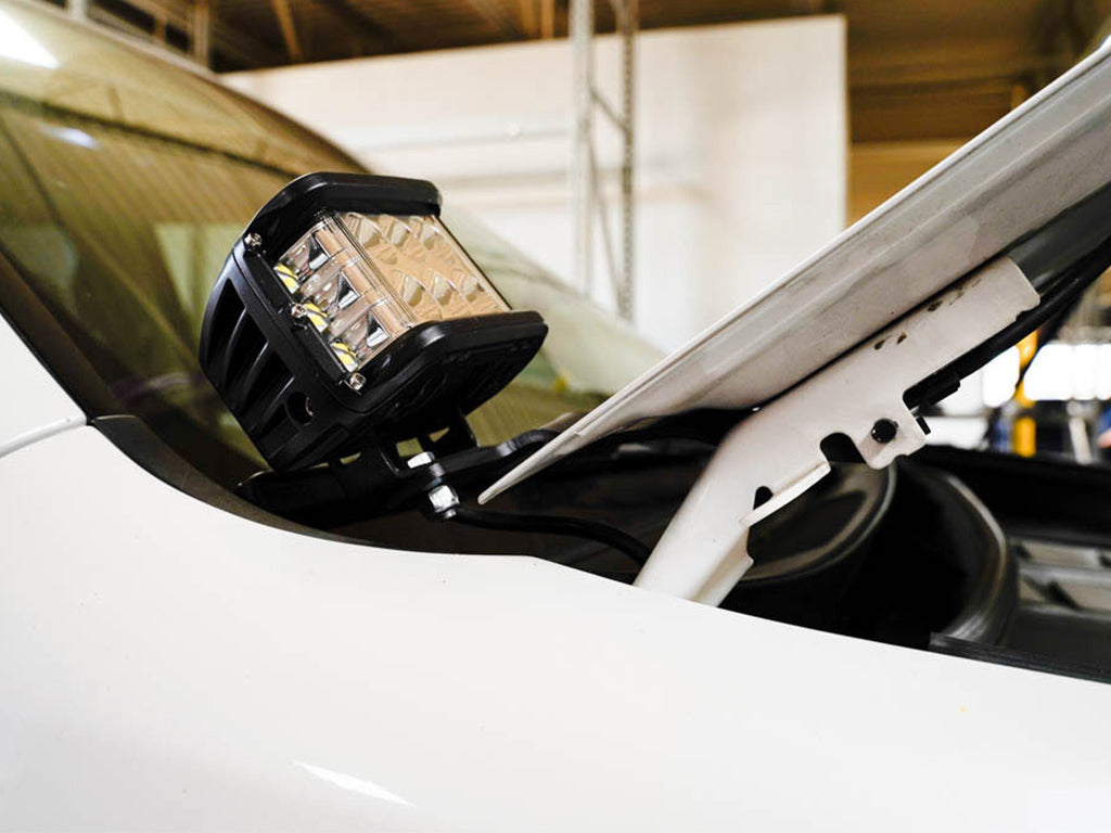 Closeup of LED ditch light bracket mounted near hood on white overlanding vehicle