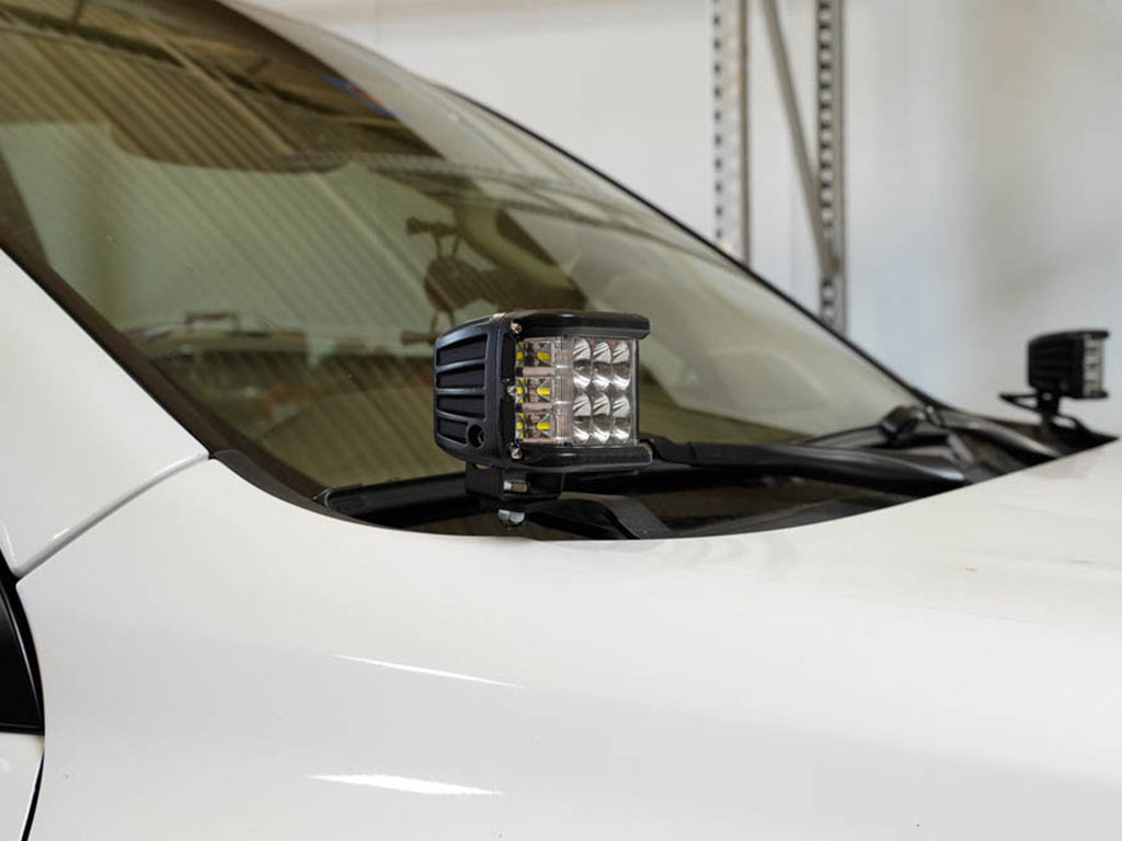 LED ditch light mounted on hood bracket of white overland vehicle