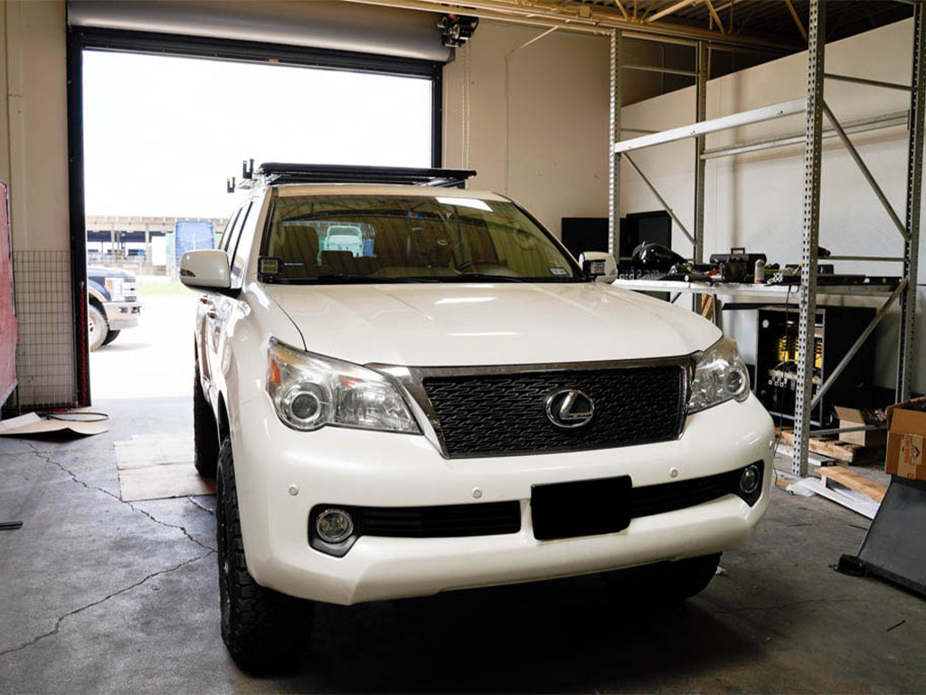 White Lexus GX parked in a garage with roof rack, ready for overlanding modifications