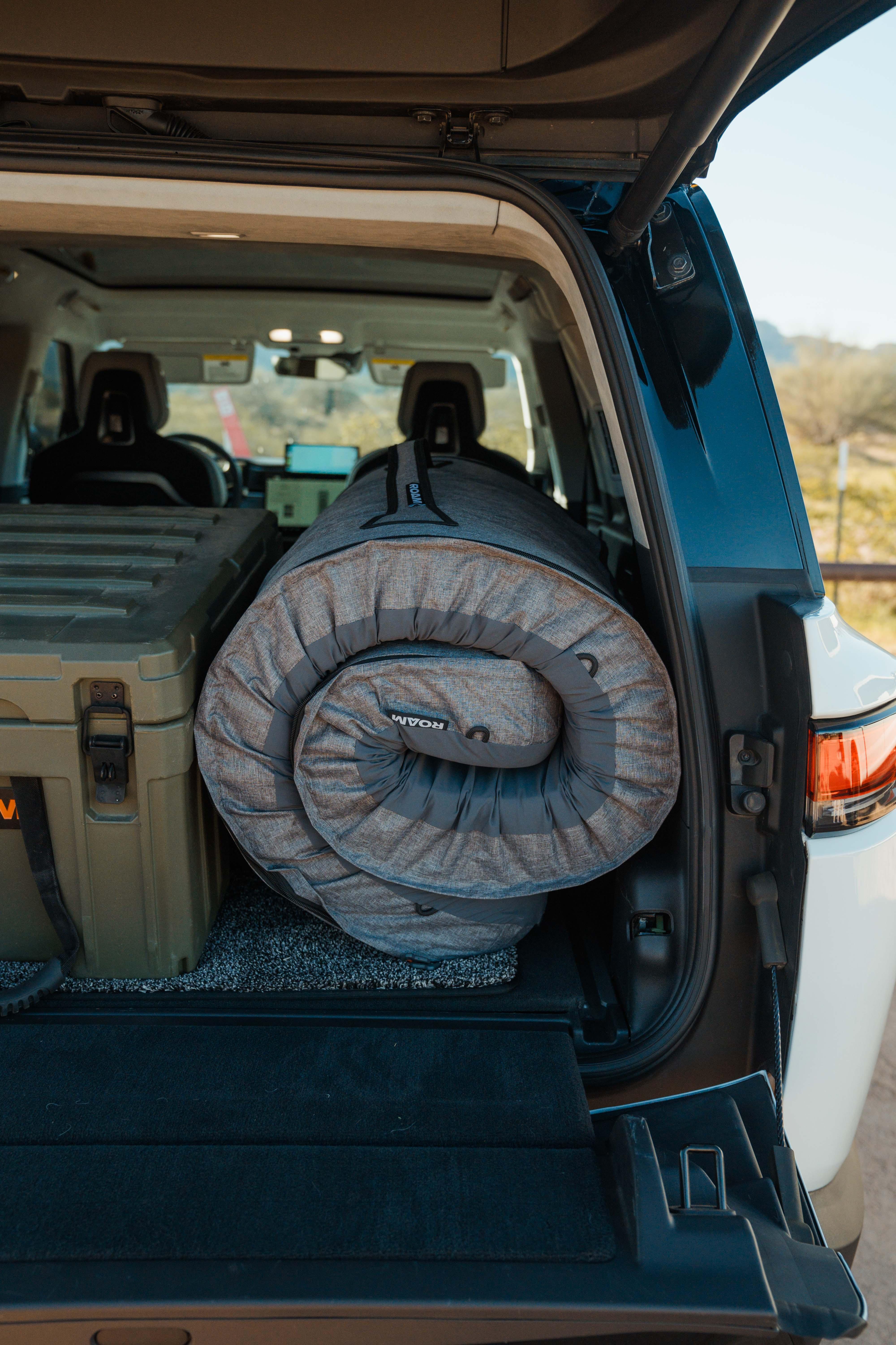 Rolled camping mattress and gear box in SUV for overlanding or expedition camping