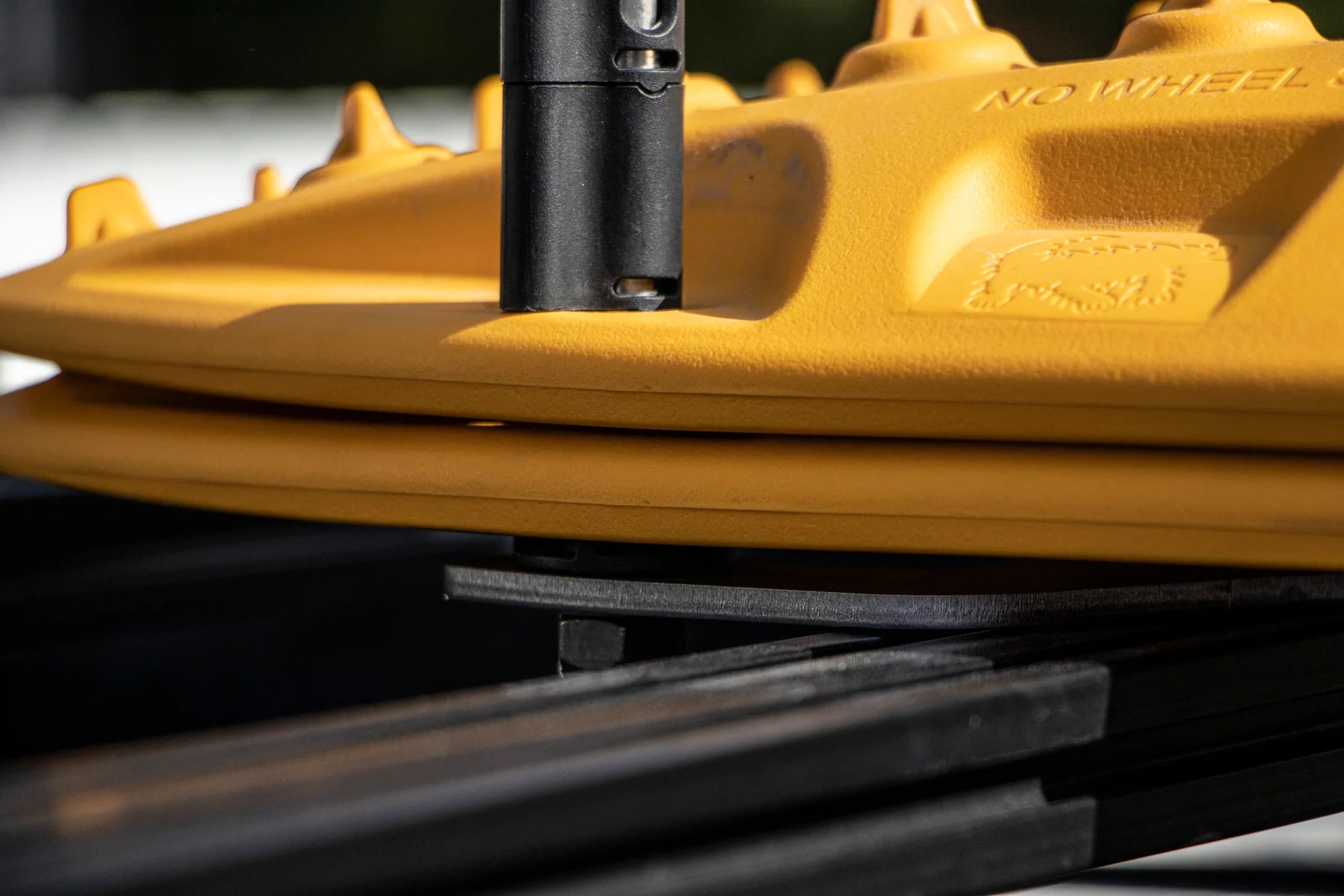 Yellow MaxTrax recovery boards mounted on a black roof rack for overlanding vehicles