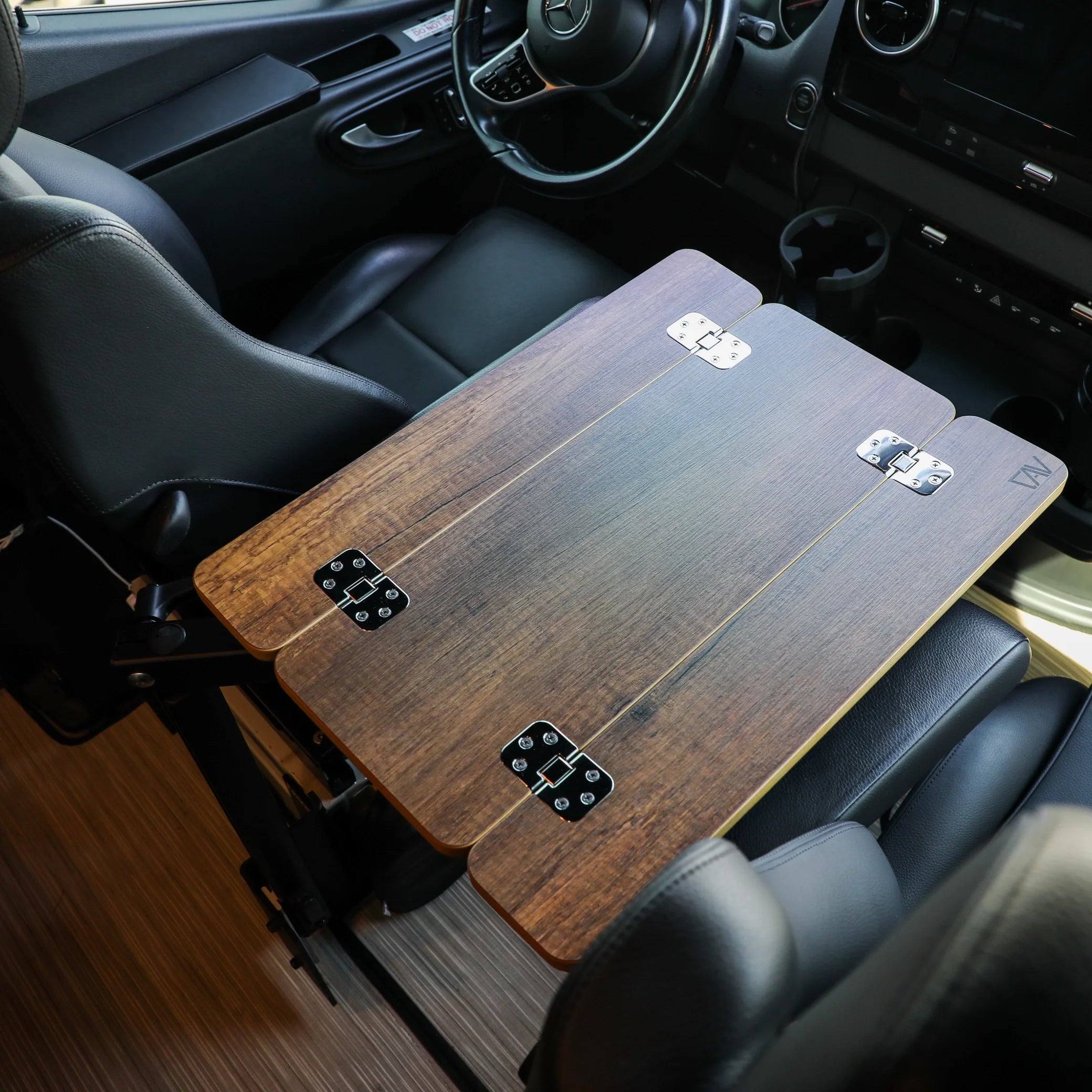 Foldable wooden overland camping table mounted inside vehicle cabin