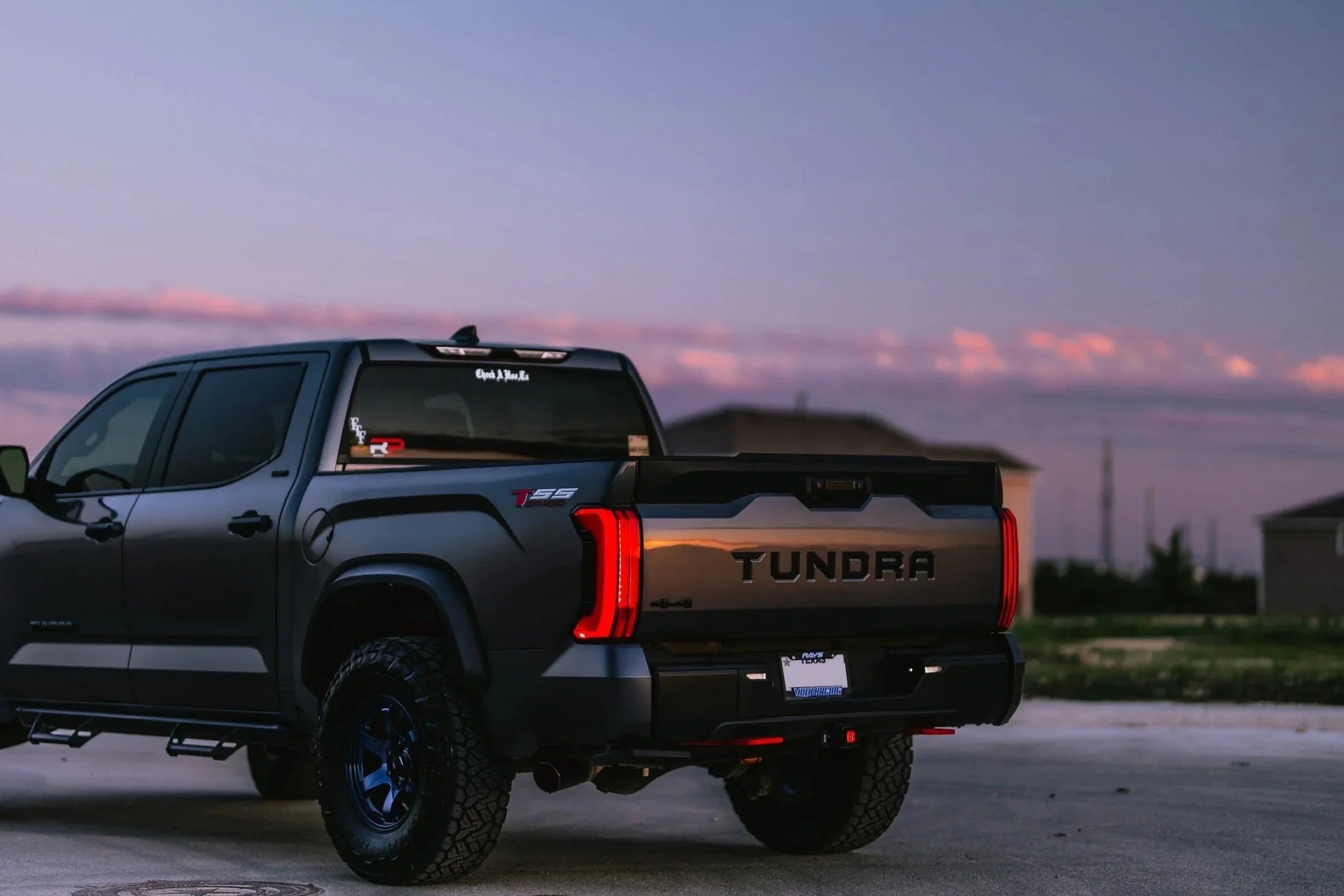 Toyota Tundra pickup truck with off-road tires parked outdoors at sunset