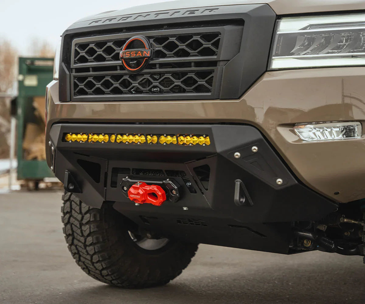 Nissan Frontier front bumper with winch, yellow light bar, and rugged off-road tires