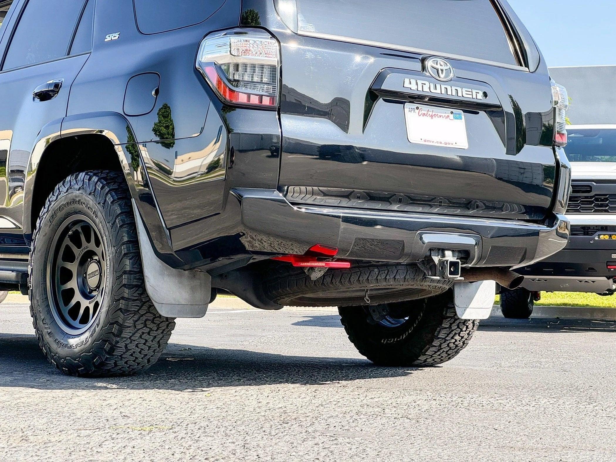 Toyota 4Runner SR5 with off-road tires, trailer hitch, and red recovery point in a parking lot