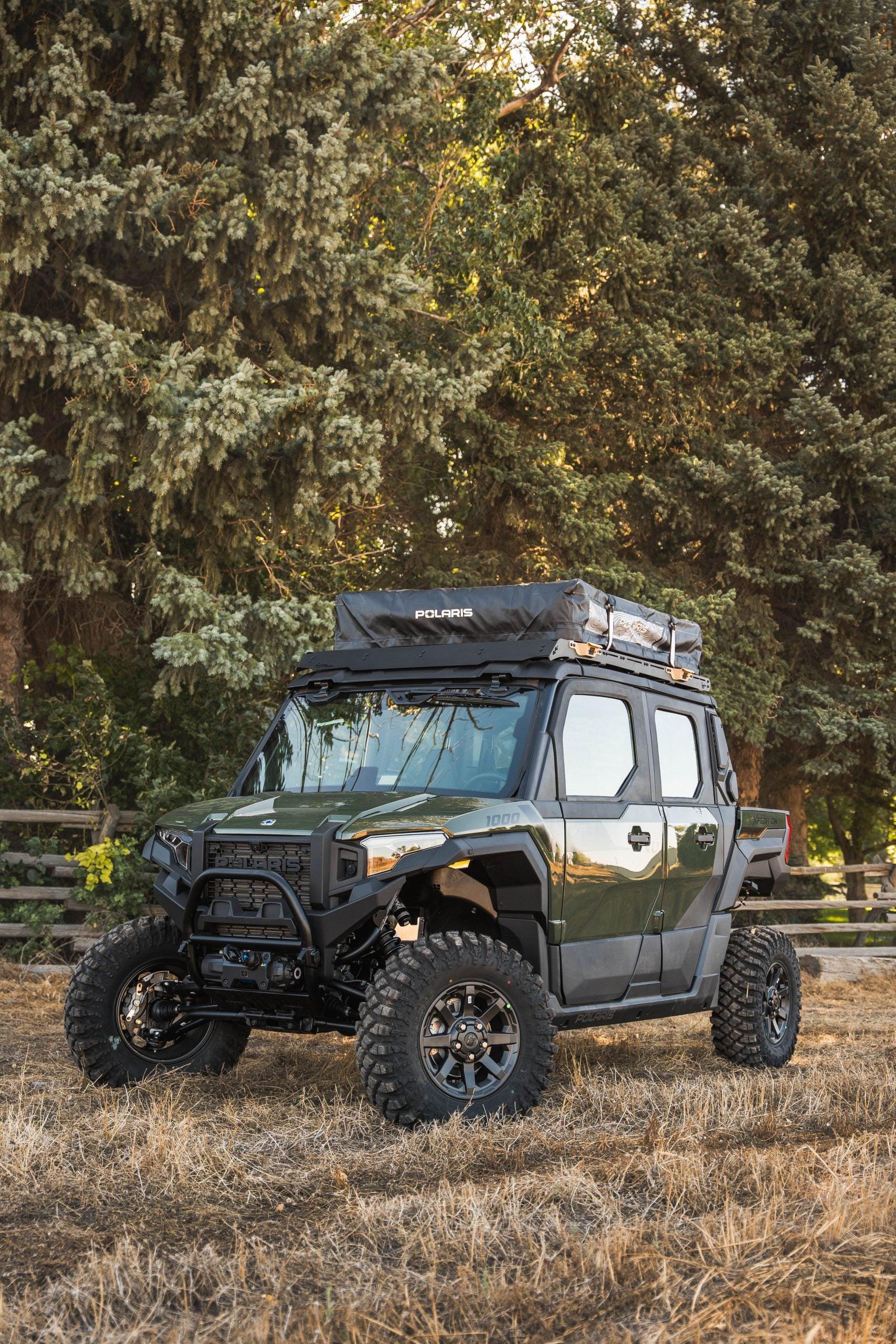Polaris expedition vehicle with rooftop tent parked outdoors, ideal for overlanding and camping