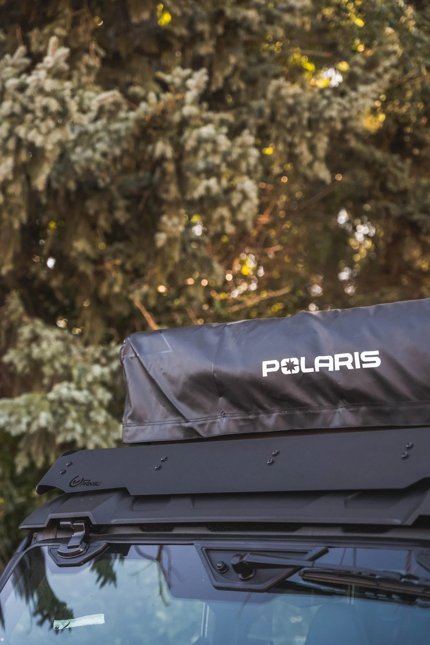 Polaris rooftop tent mounted on overlanding vehicle with forest background