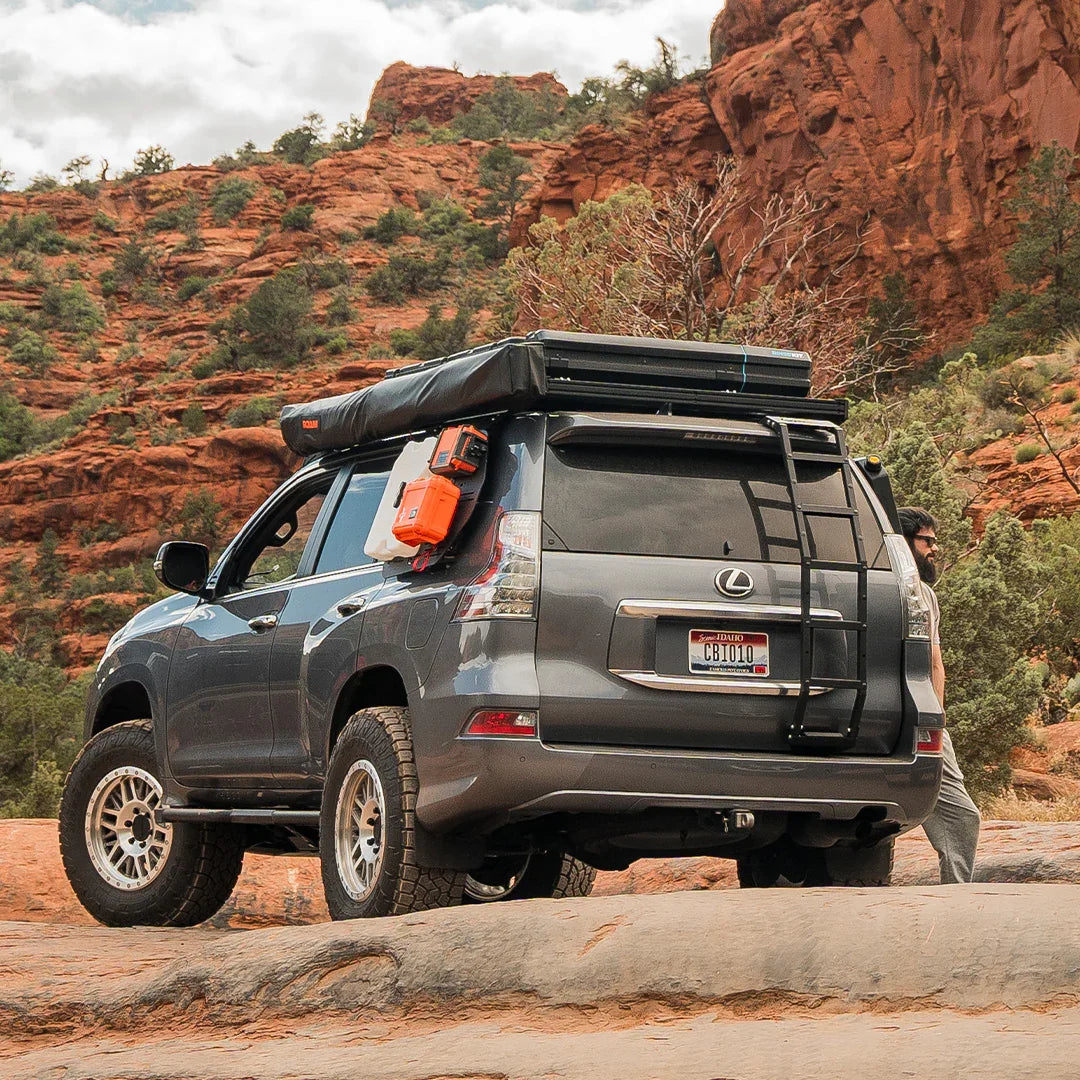 Lexus GX460 with Prinsu roof ladder and overlanding gear in a desert canyon landscape
