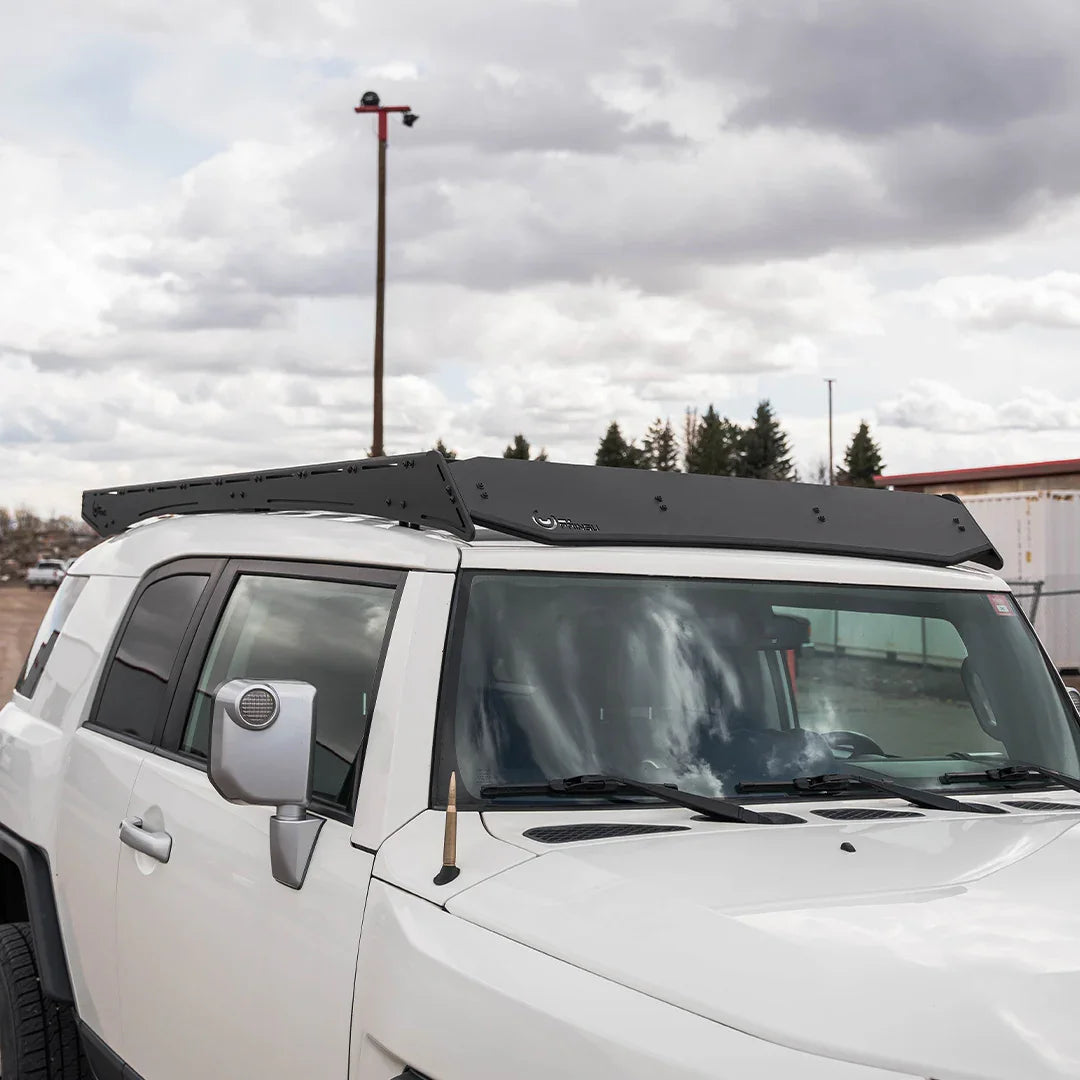 Black roof rack installed on white Toyota FJ Cruiser, overland vehicle accessory.