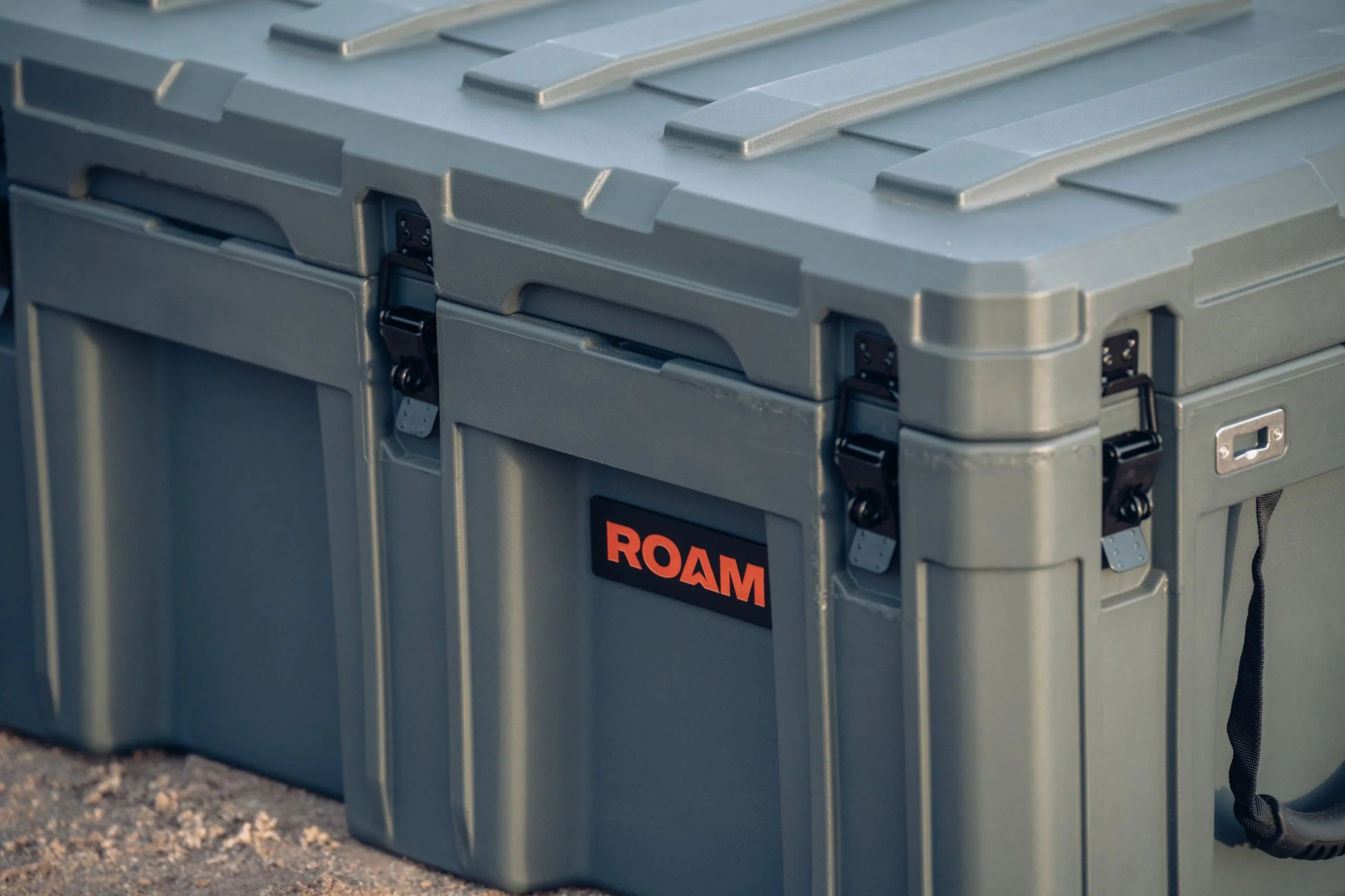 Heavy-duty gray storage case with latches, ROAM logo, for overlanding and camping gear