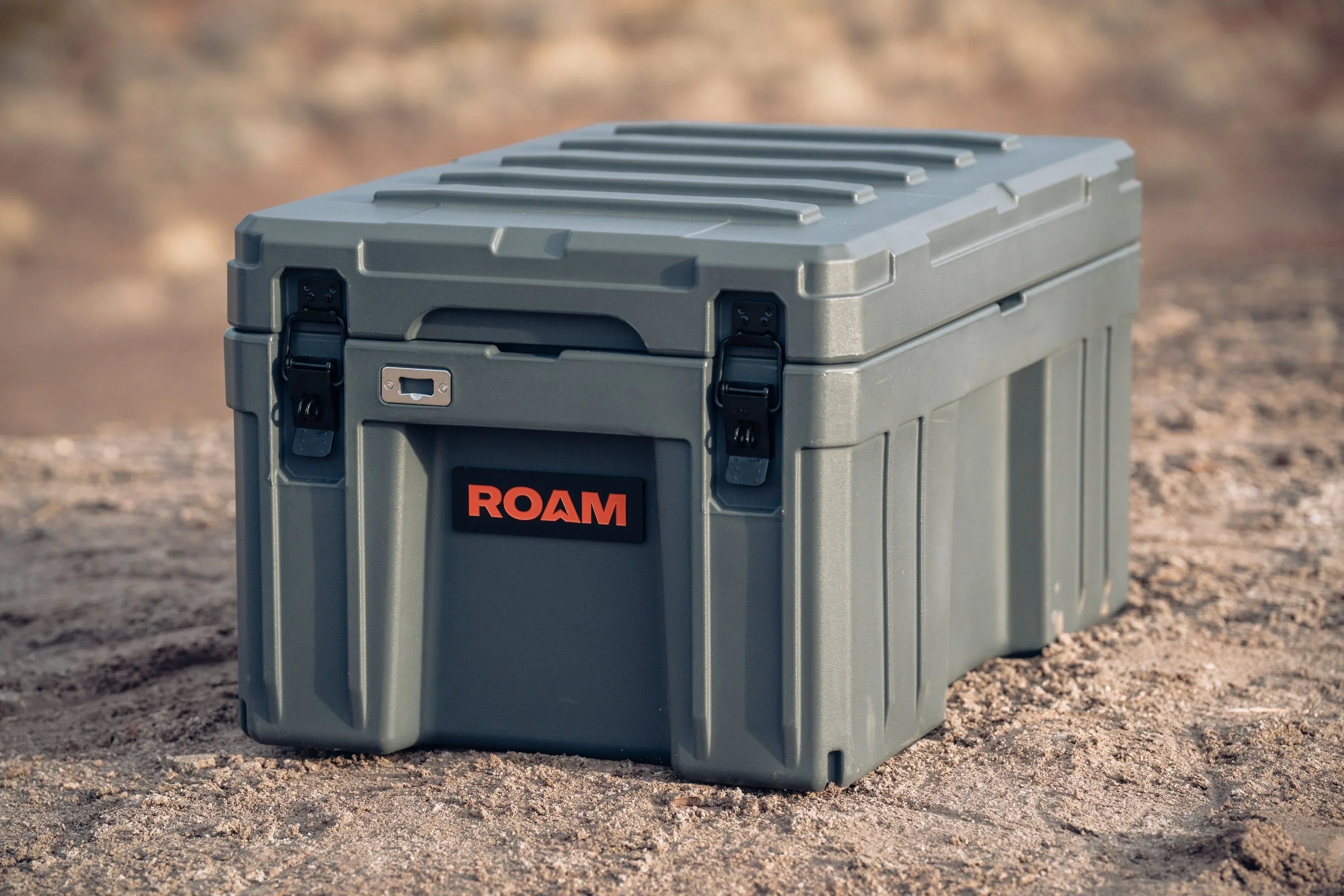 Outdoor heavy-duty overland storage box with ROAM logo on rugged terrain