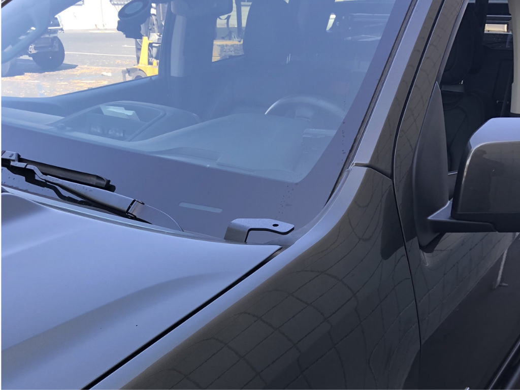 Close-up of front windshield and wiper on an off-road vehicle, showing hood details
