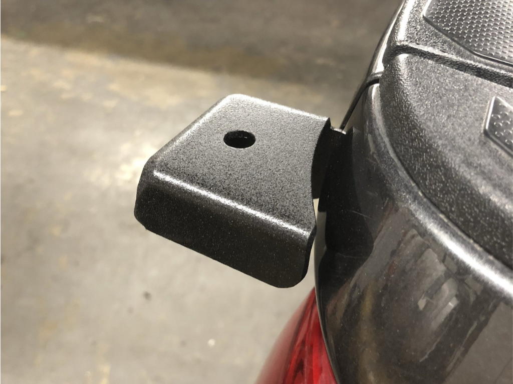 Powder-coated metal accessory mount bracket installed on a vehicle tailgate