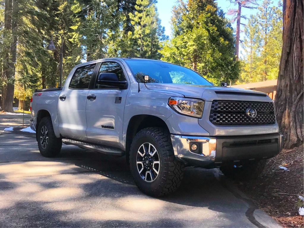 Toyota Tundra pickup truck with off-road tires parked in a forested outdoor setting