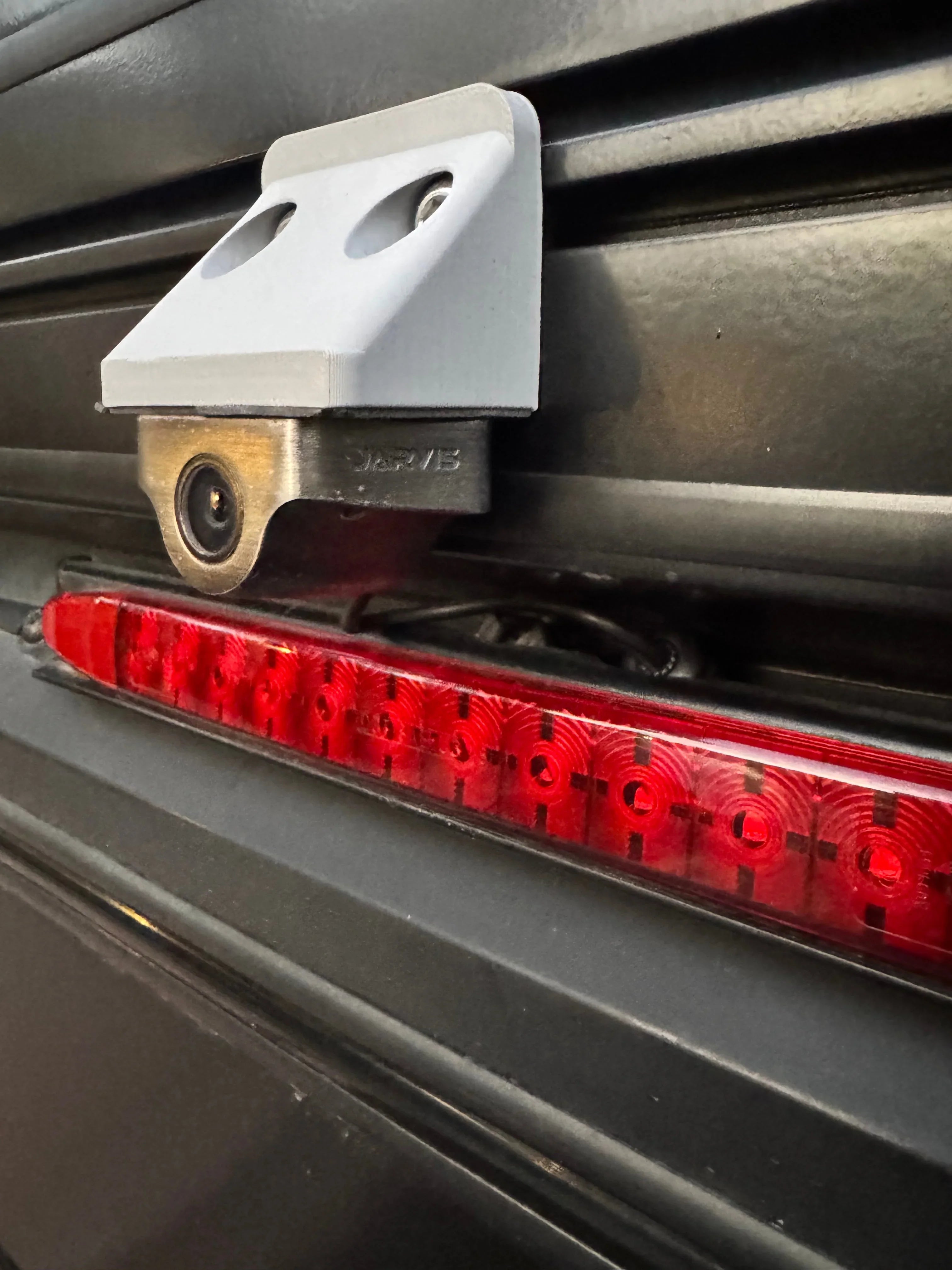 Rear camera relocation mount installed above vehicle LED brake light