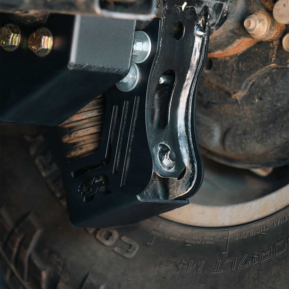 Rear shock skid plate installed on 2024 Toyota Tacoma suspension with visible bolts