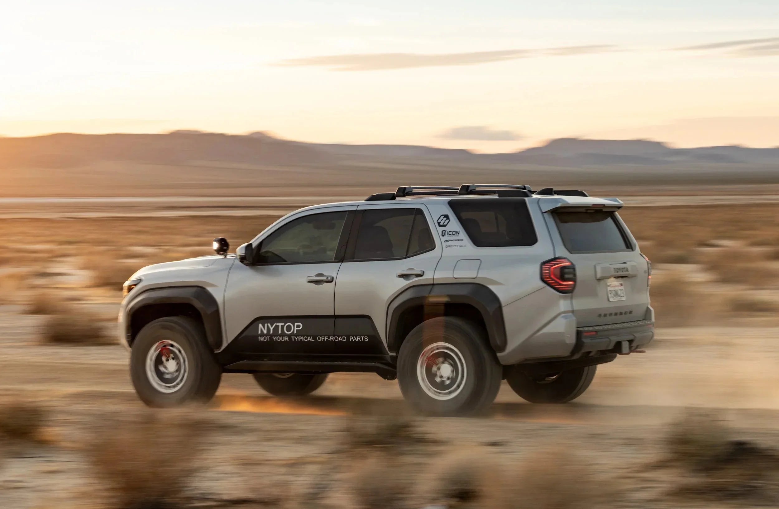 Toyota 4Runner off-road SUV driving in desert with custom expedition accessories at sunset