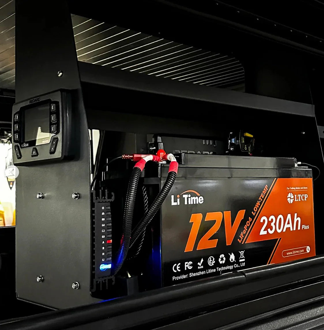 12V 230Ah LiFePO4 battery installed in overlanding vehicle with monitor and wiring