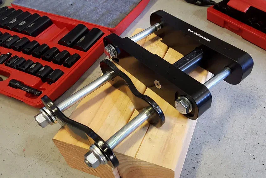 Heavy-duty shackle tool and socket set on workbench for off-road vehicle suspension upgrade