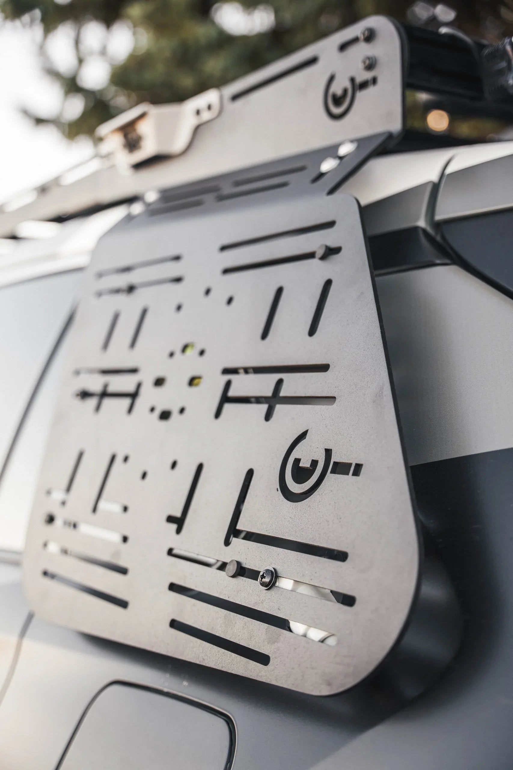 Close-up of a modular metal side panel mounted on an overlanding vehicle for gear storage.