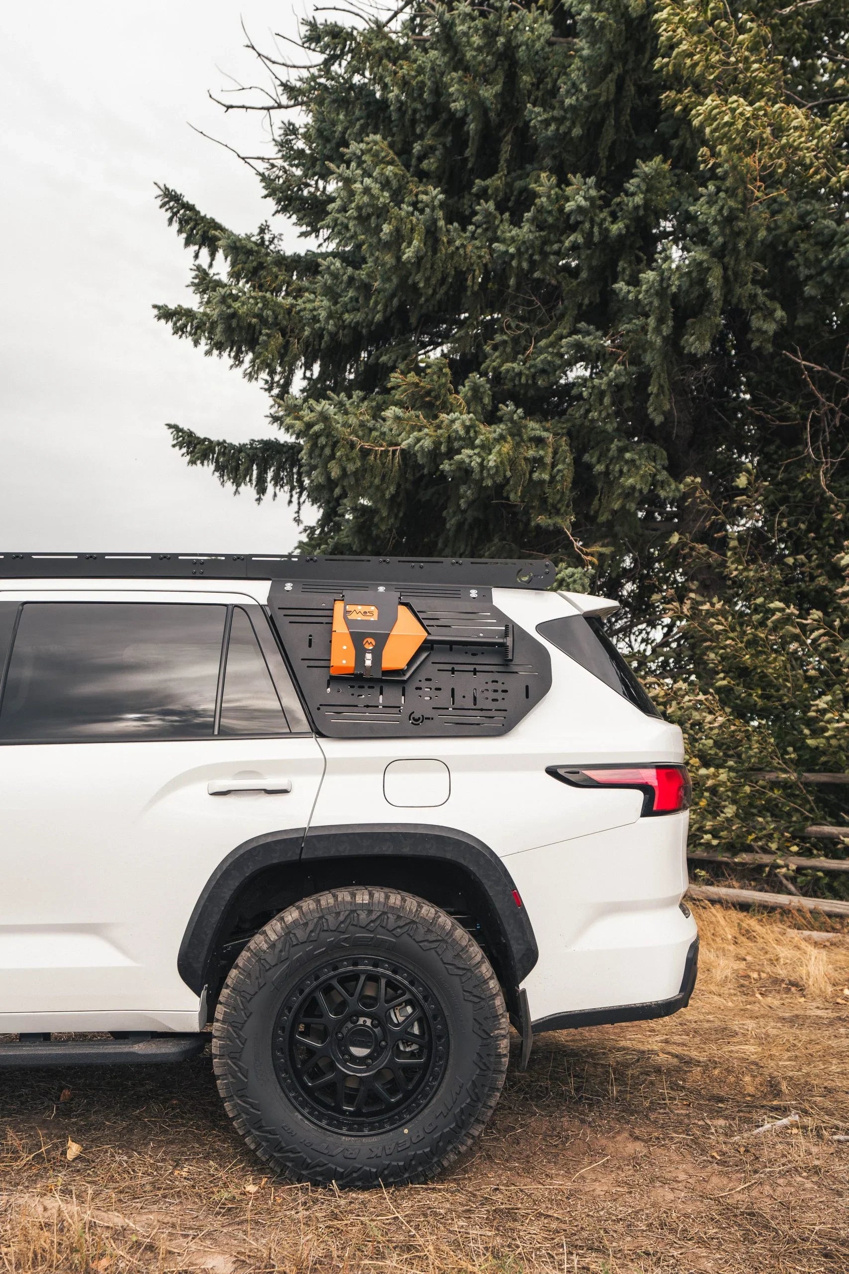 Overland SUV with modular side panel gear mount in forest outdoor setting