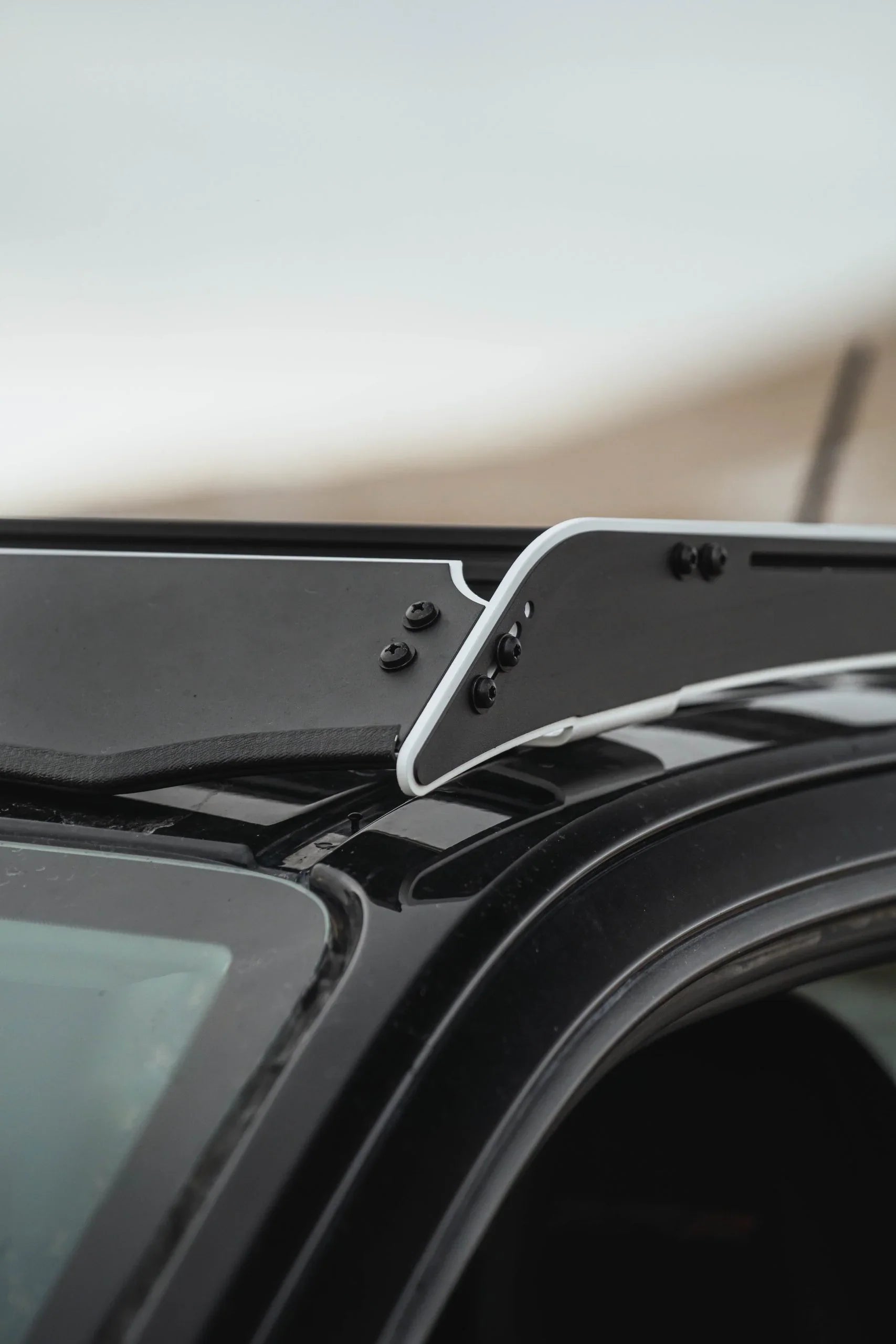 Close-up of black metal side shield accessory mounted on vehicle roof rack