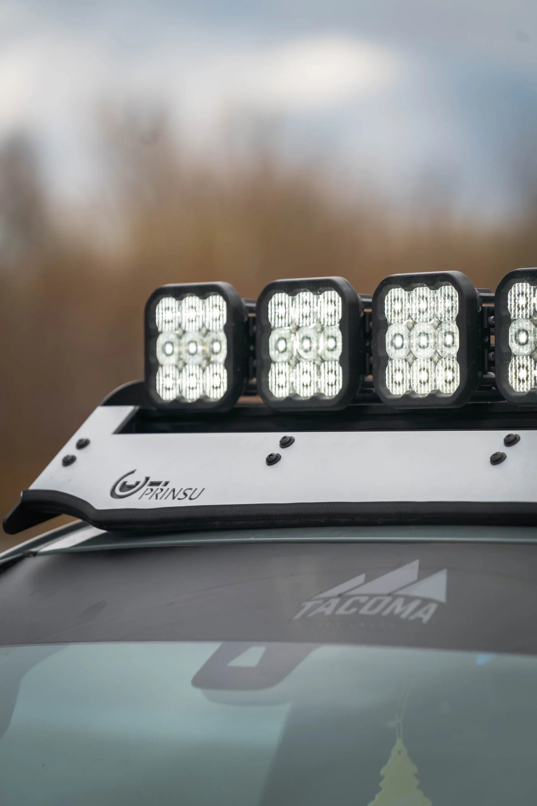 Close-up of roof rack LED lights and wind fairing on a Toyota Tacoma for overlanding