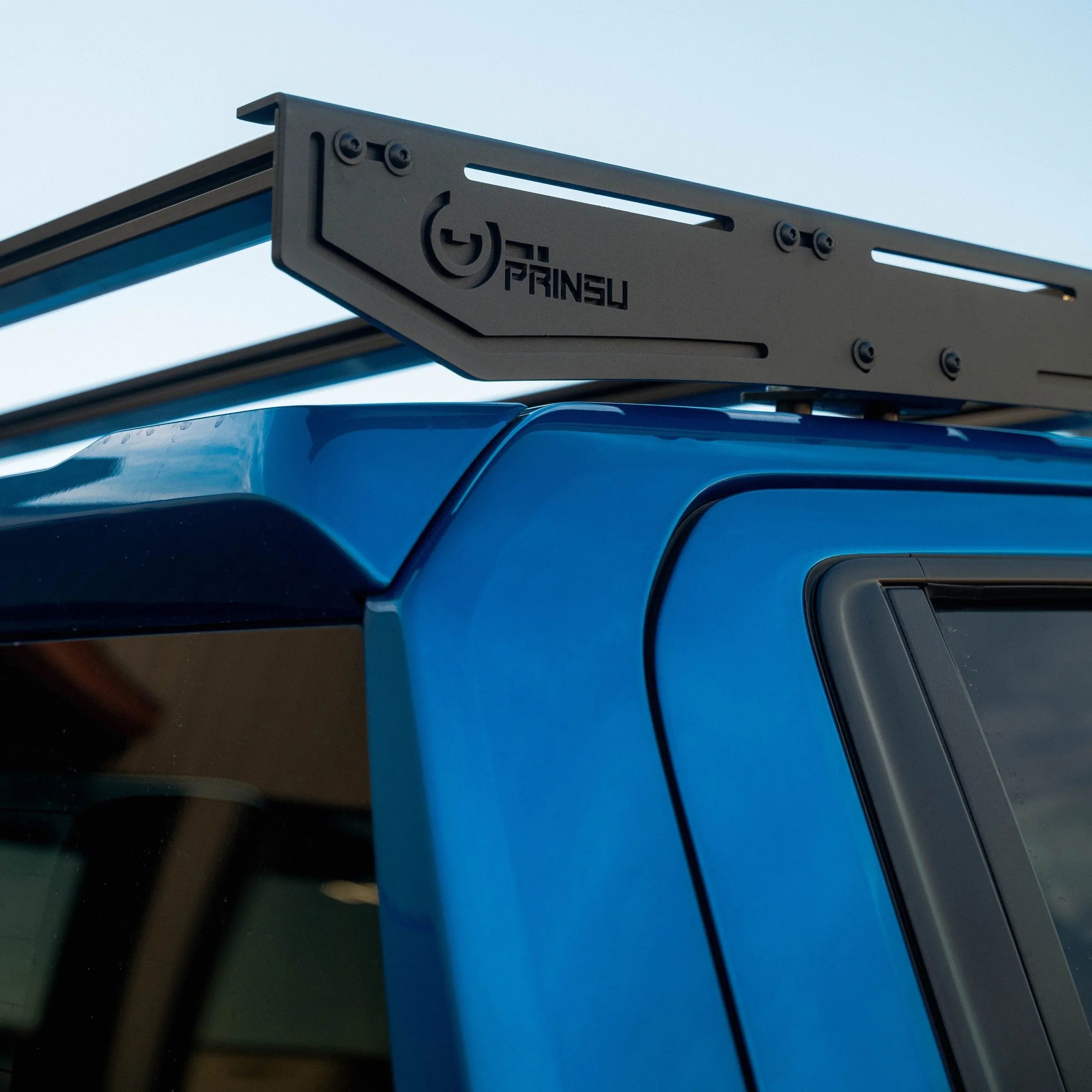 Close-up of Prinsu roof rack on a blue pickup truck, ideal for overlanding gear