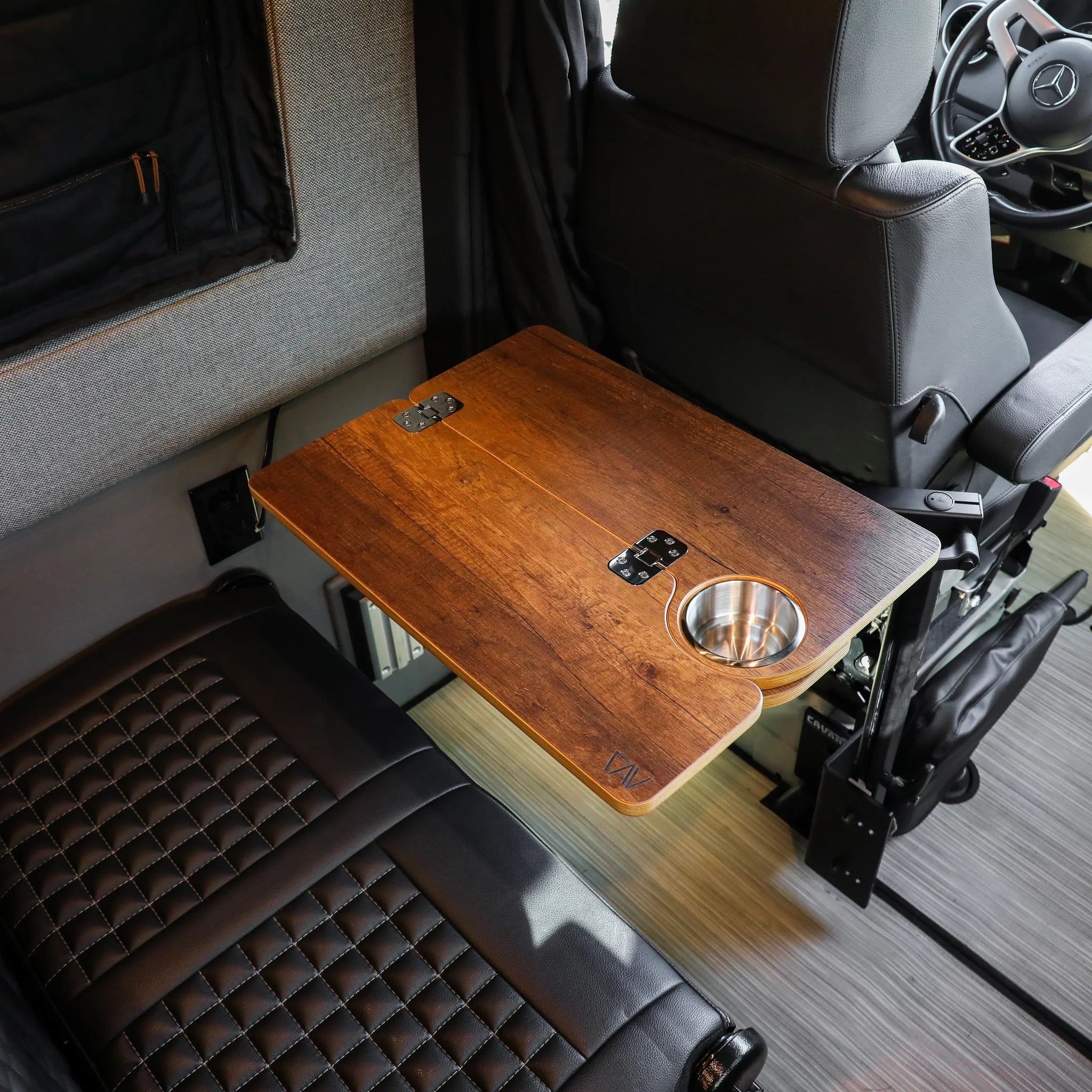Foldable wood vehicle table with built-in cup holder, mounted between van seats