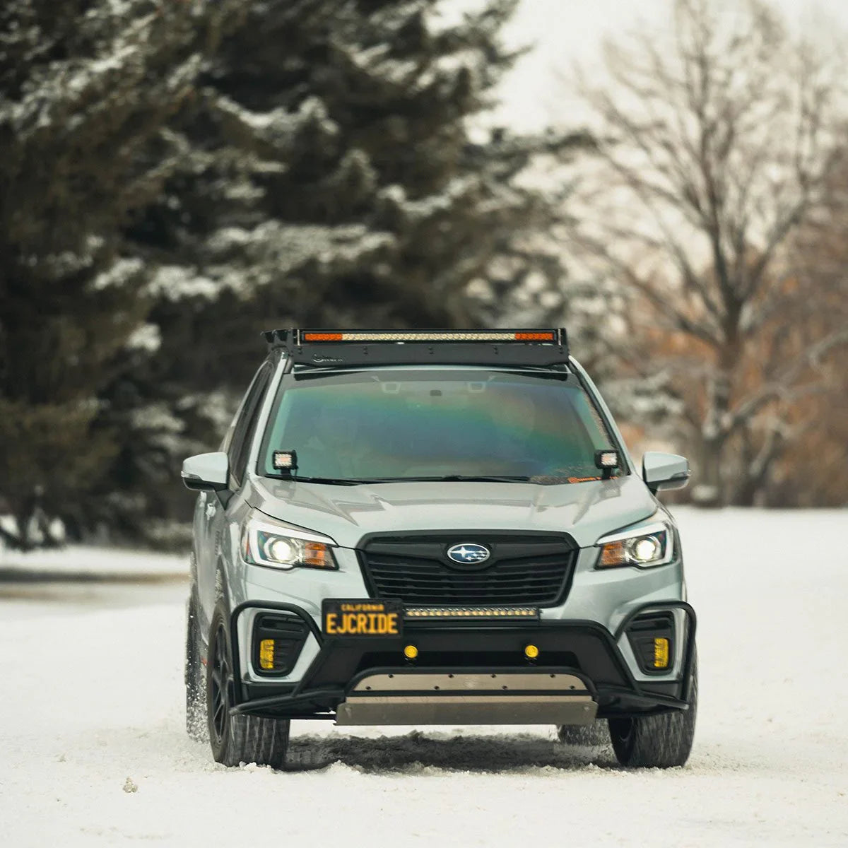 Subaru Forester with Prinsu roof rack and LED light bar driving on snowy road