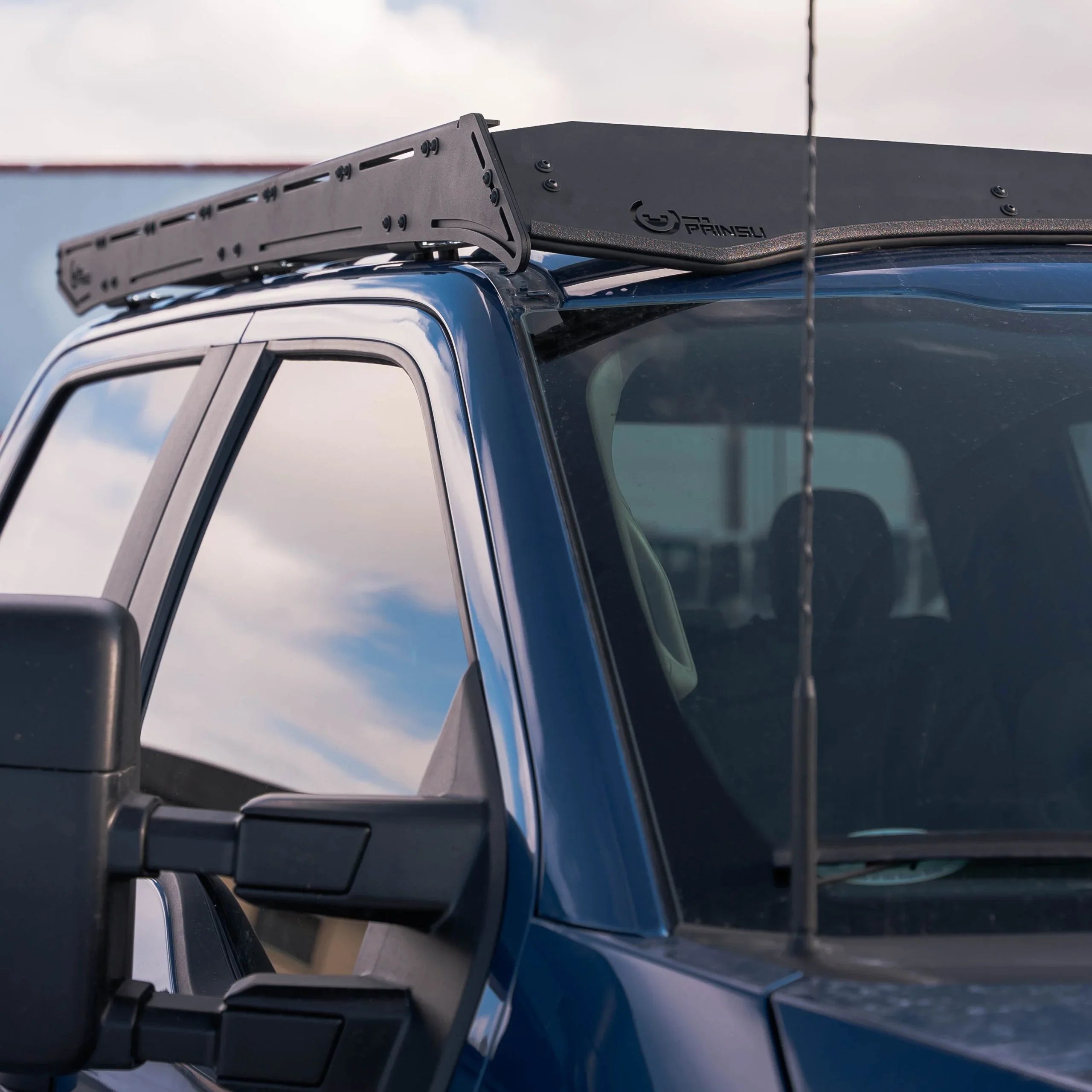 Heavy-duty roof rack installed on a blue pickup truck for overlanding and camping gear