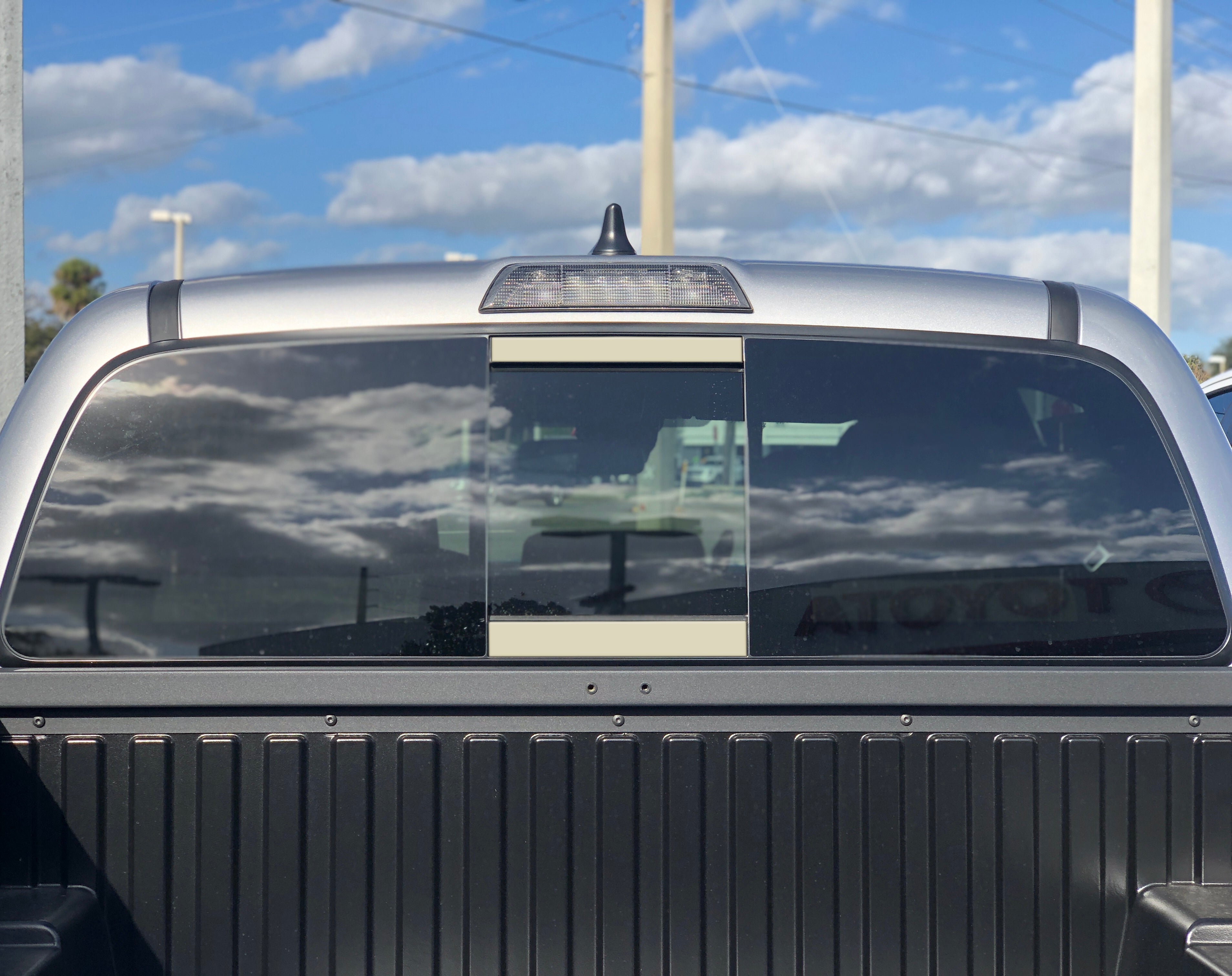 Toyota Tacoma rear cab window with sliding glass, viewed from the truck bed