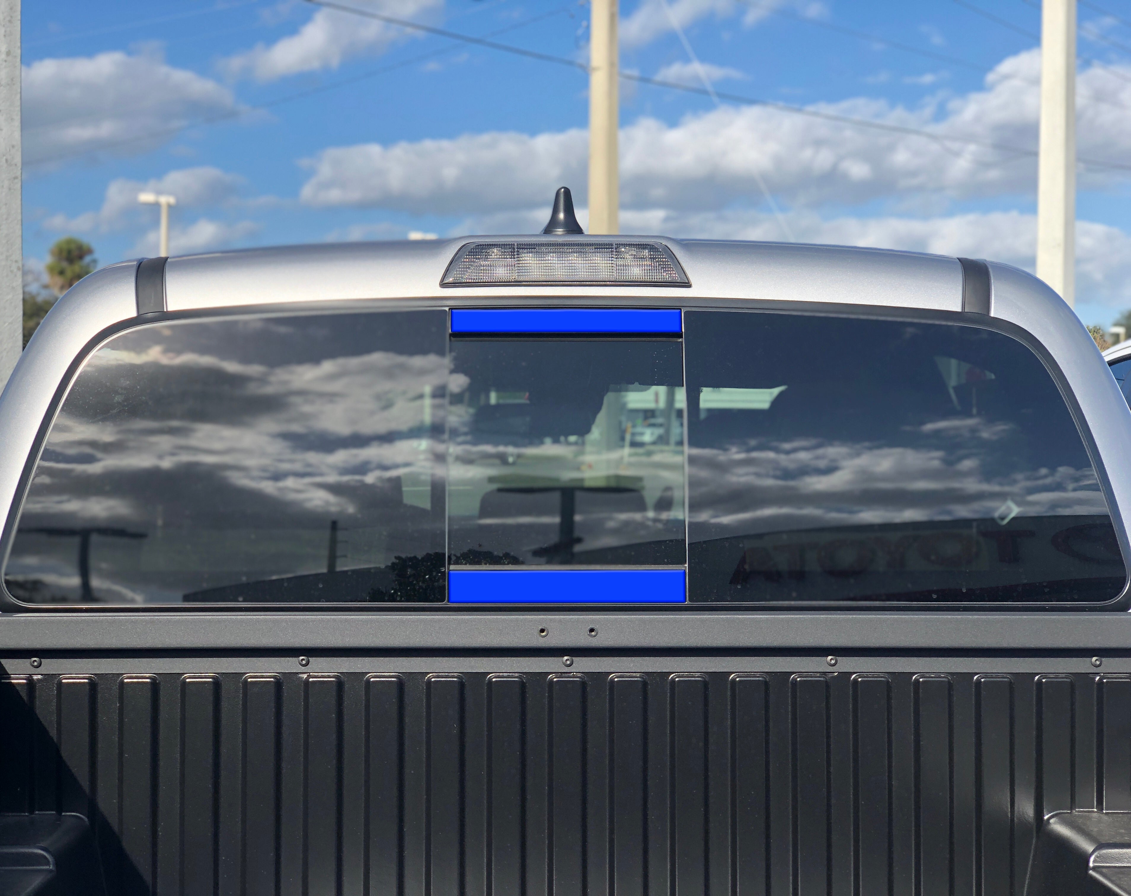 Toyota Tacoma rear window with blue molle panel for overlanding gear