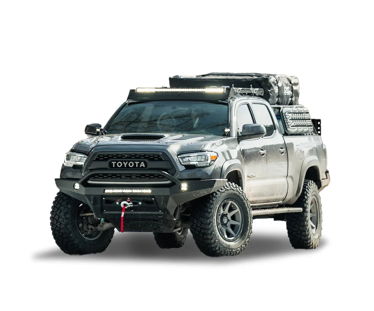 Toyota Tacoma overland truck with off-road tires, roof rack, and expedition gear