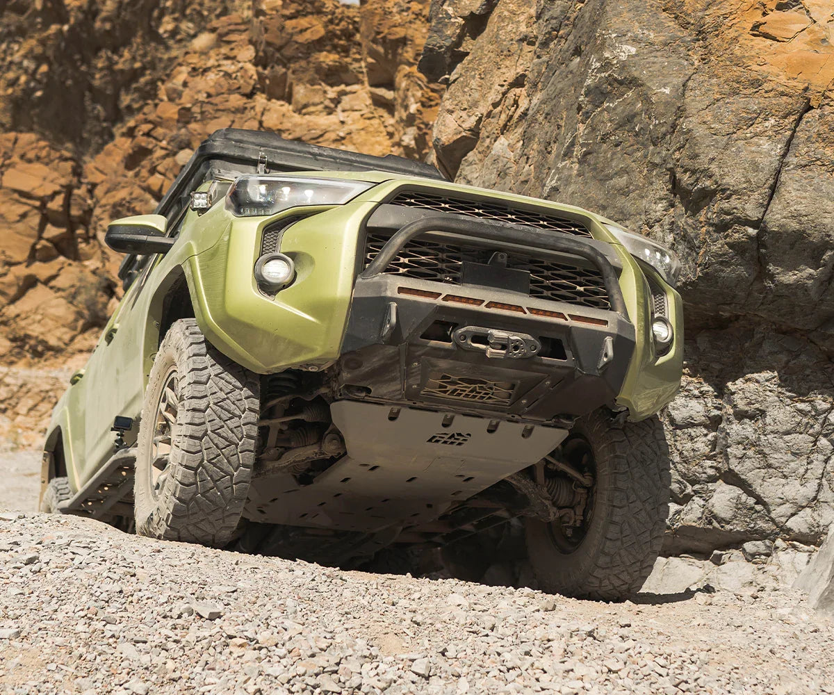 Toyota 4Runner with rugged front bumper off-roading on rocky desert terrain