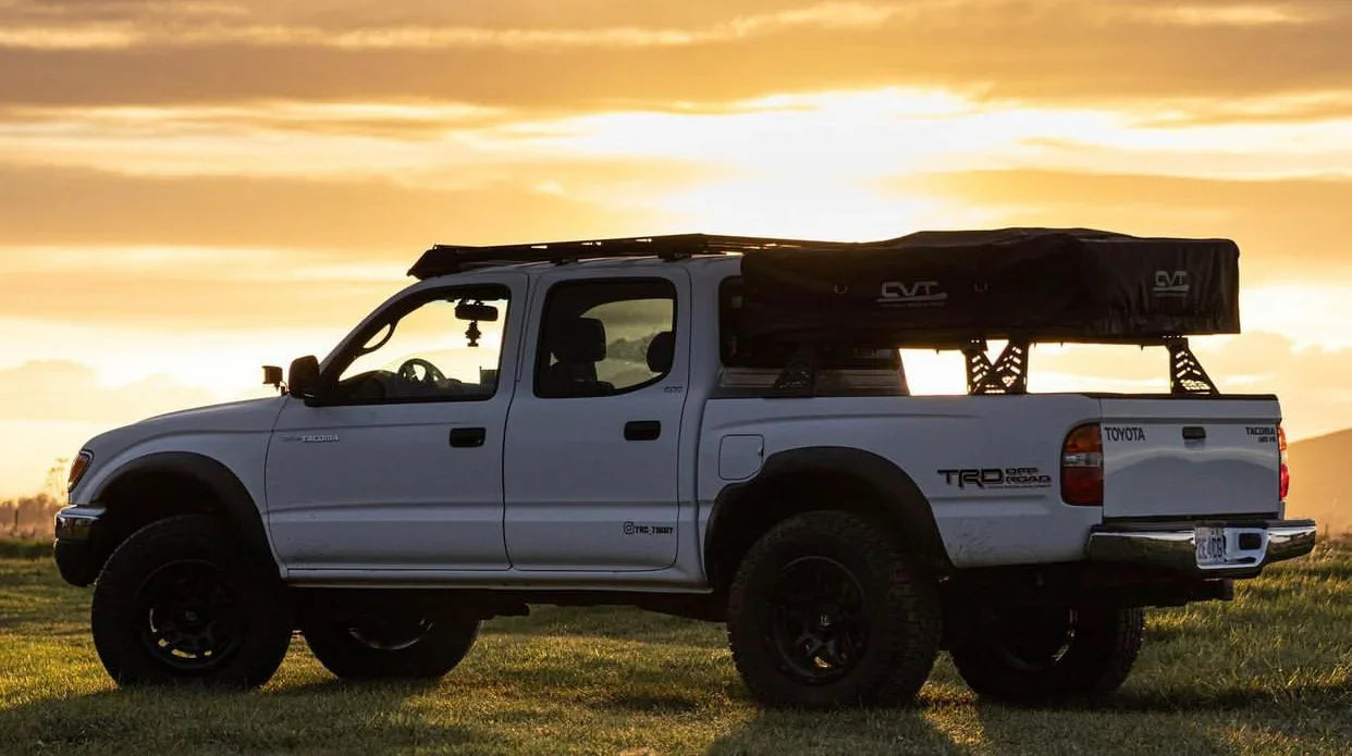 1996-2004 Toyota Tacoma with CBI overland bed bars and roof tent at sunset