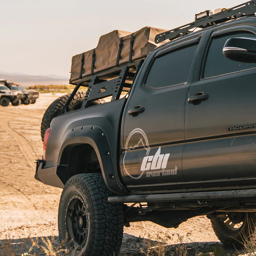 Toyota Tacoma with overland bed rack and rooftop tent parked off-road