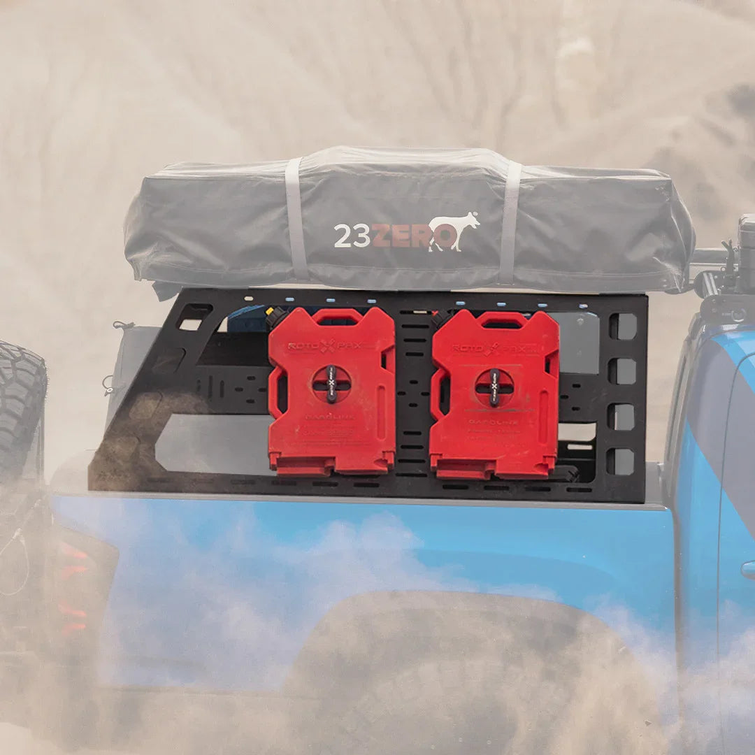 Toyota Tacoma bed rack with rooftop tent and red fuel containers in an off-road setting