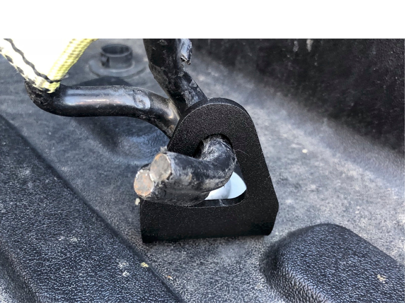 Upgraded bed tie down installed on truck bed rail, securing a strap hook